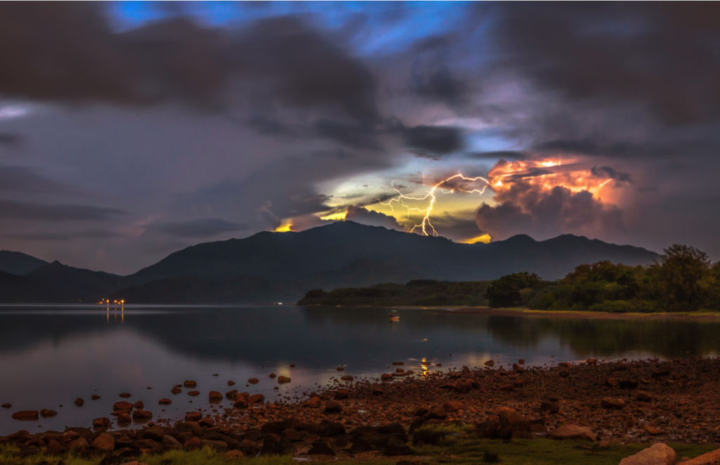 lightning over lake with sunset clouds