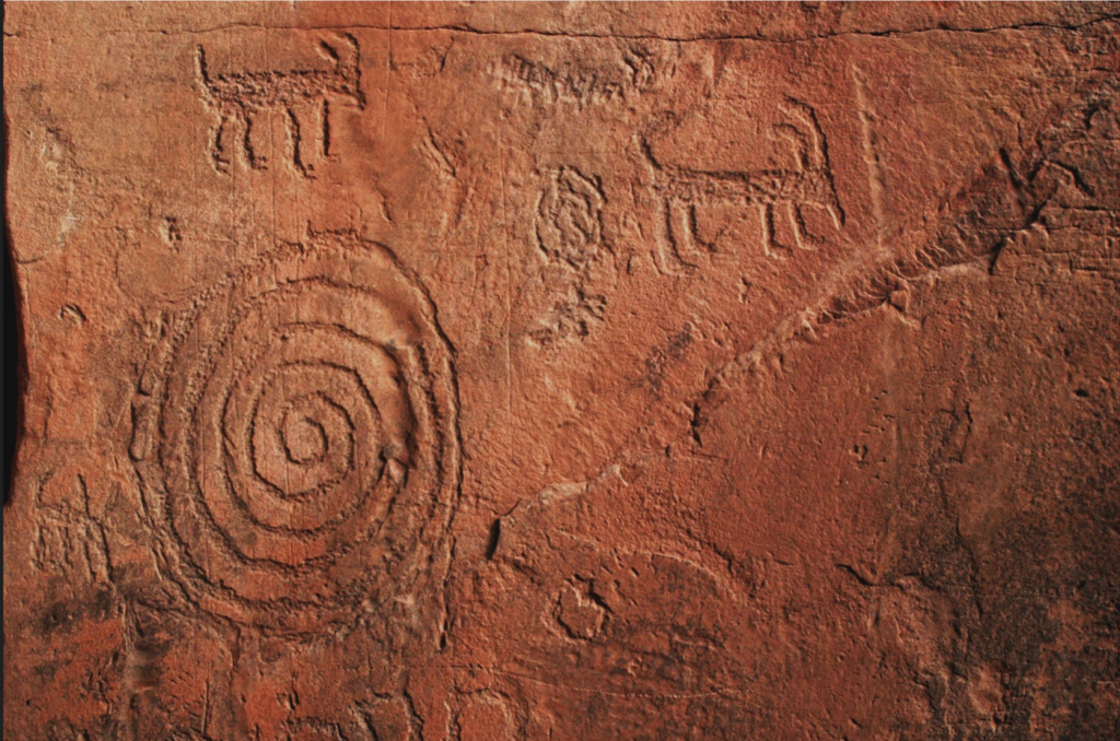 petroglyph: large spiral with four-legged horned animals