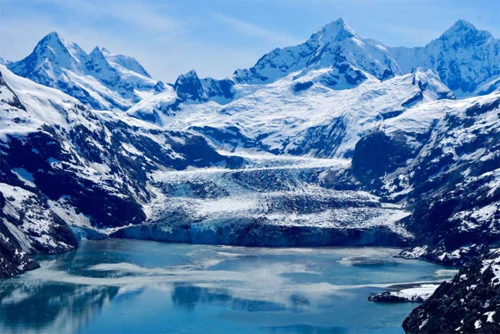 snowy mountain peaks above glacial lake